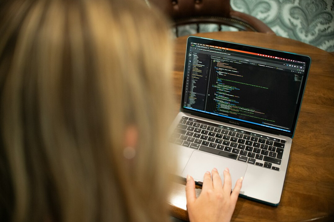 student coding on laptop