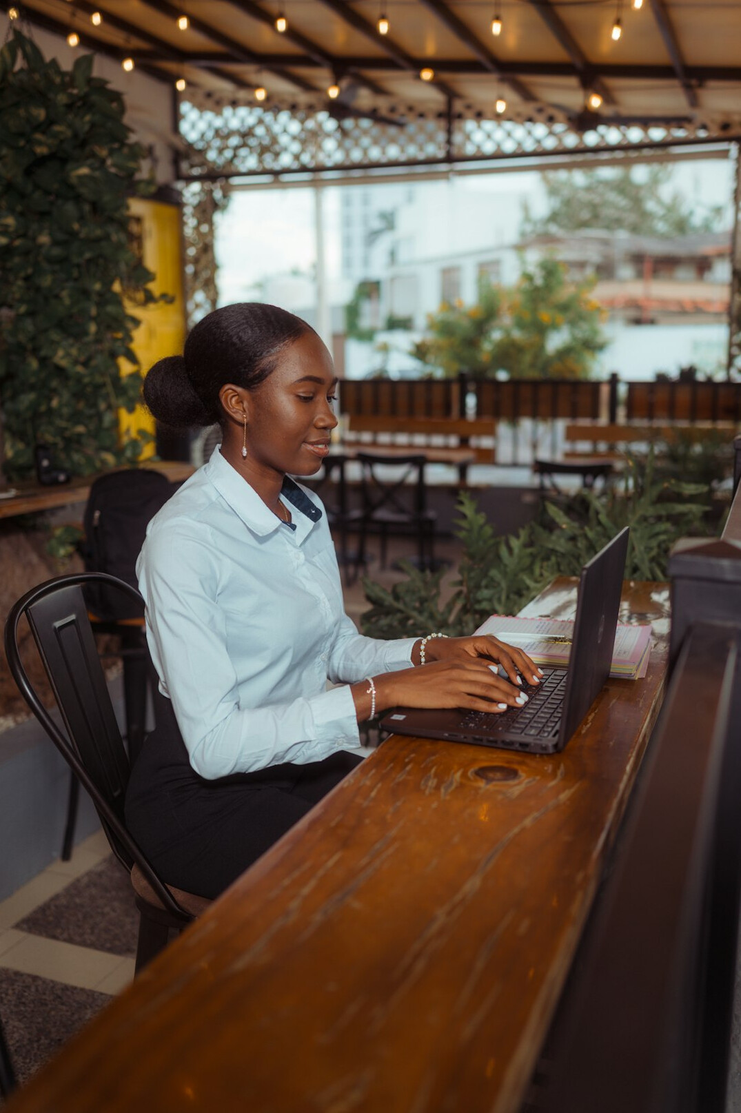 person coding on laptop in cafe