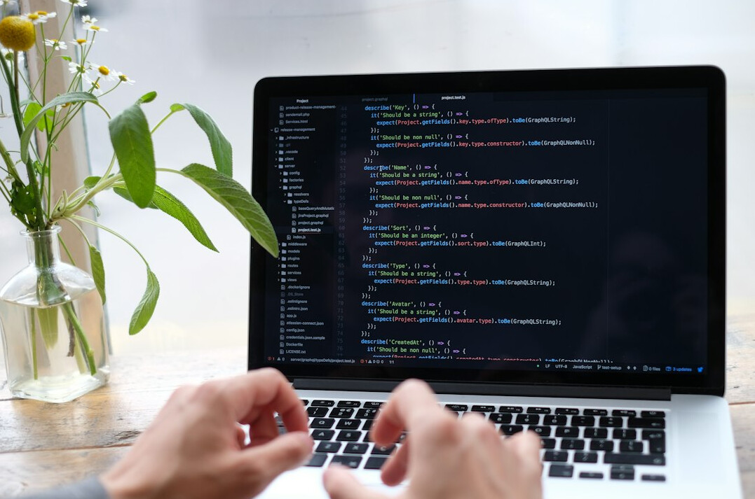 programmer coding on laptop