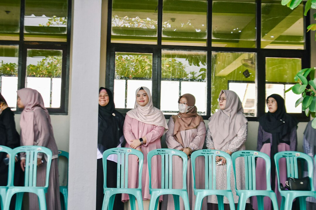 Diverse group of Malaysian programming instructors and students gathered in a bright office