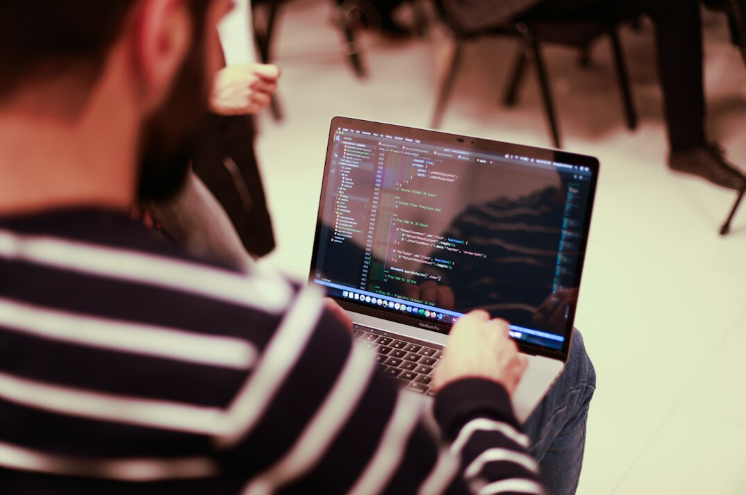 person coding on laptop